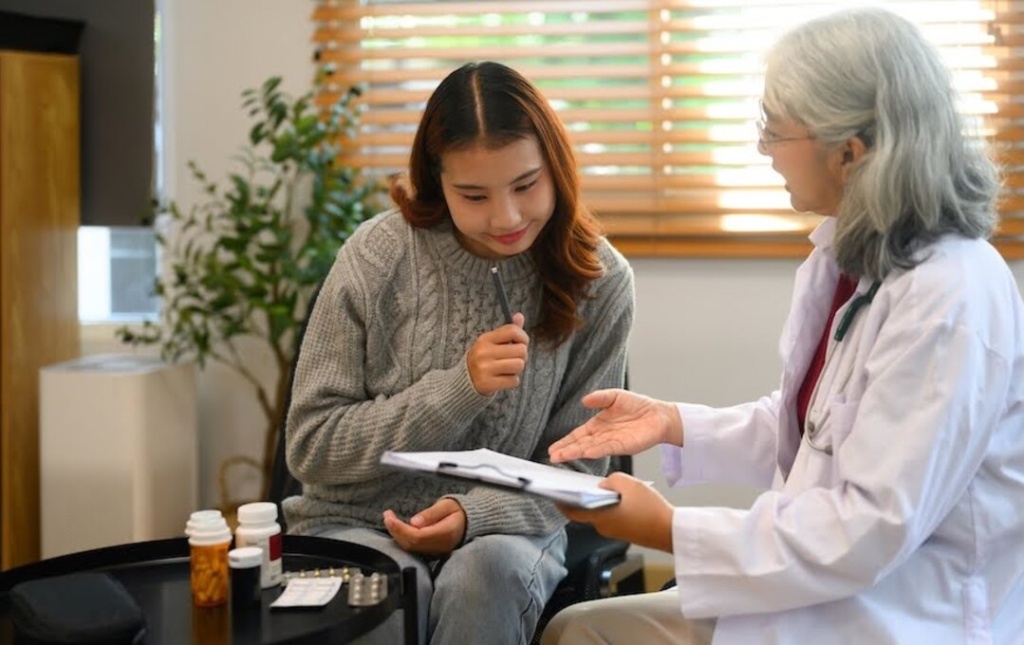 Senior female doctor explaining menopause treatment options to a patient