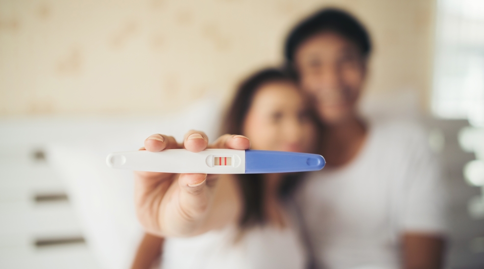 excited new parent hand show pregnancy test after fertility treatment.